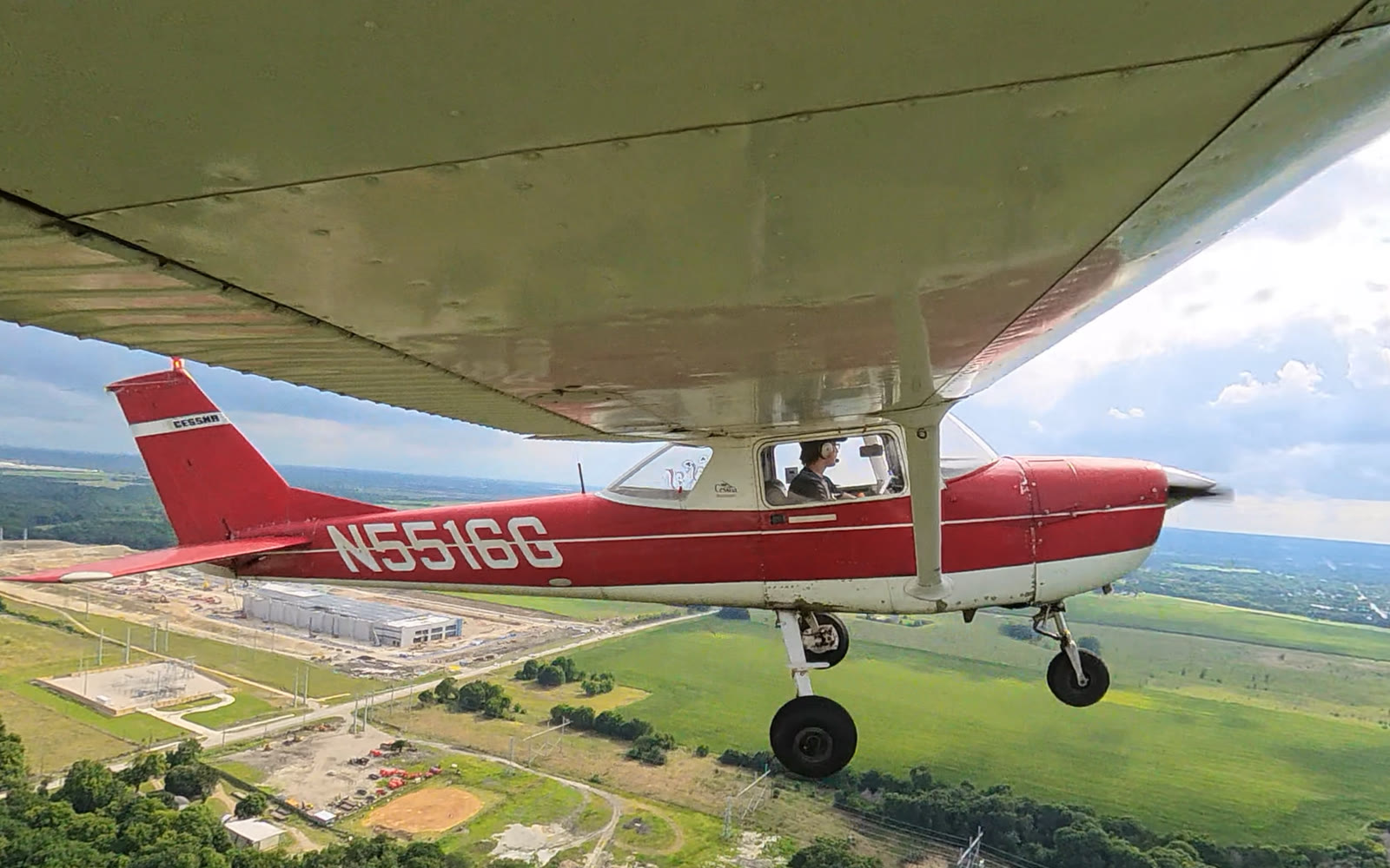 Red and white Cessna 150 N5516G in flight